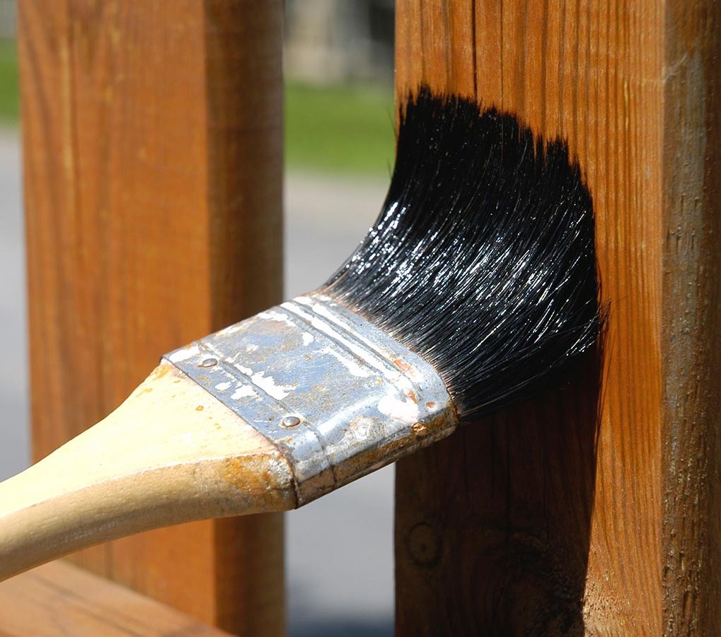 Pflege und Lasuren für Holzschutz für Ihren Zaun und Sichtschutz bei Holz Fichtl Nahaufnahme Zaun wird mit Pinsel gestrichen