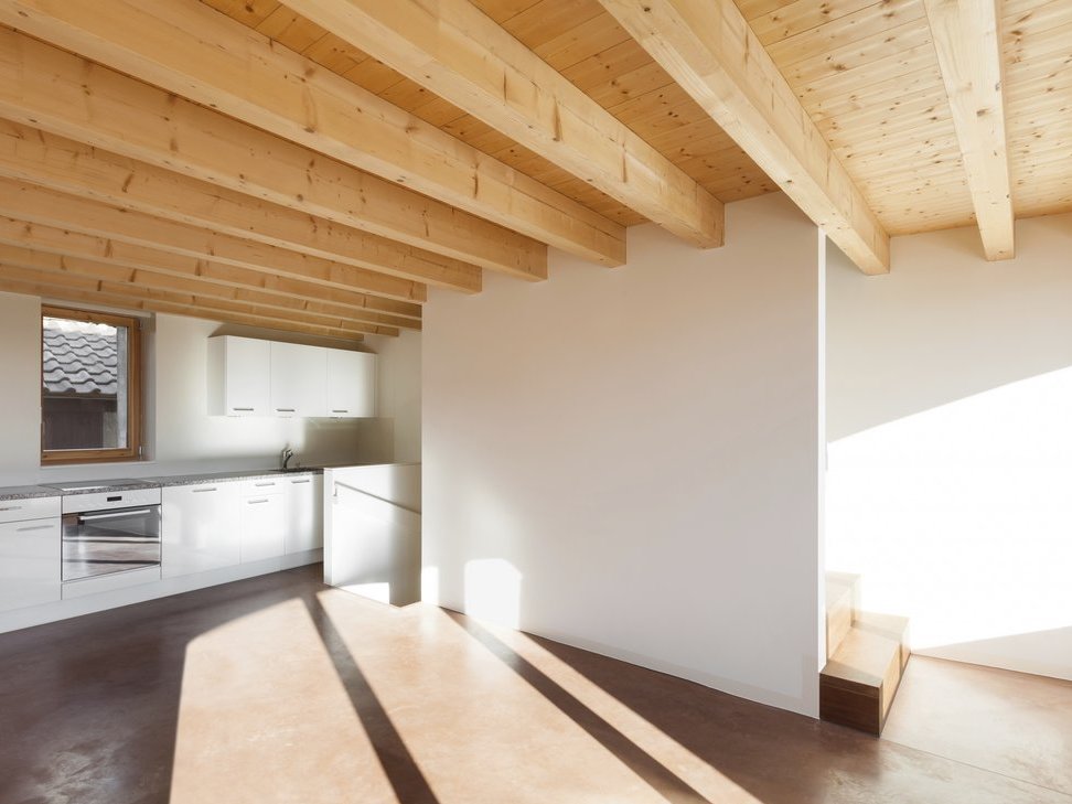 Leerer Wohnraum mit Holzbalkendecke